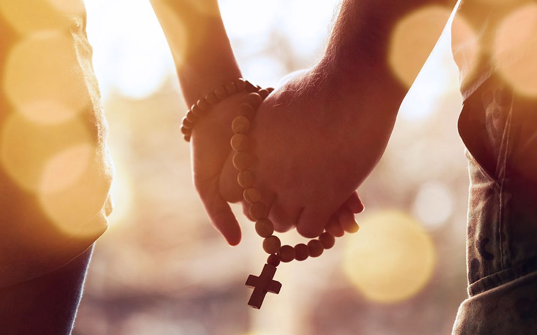 Couple holding hands with Rosary