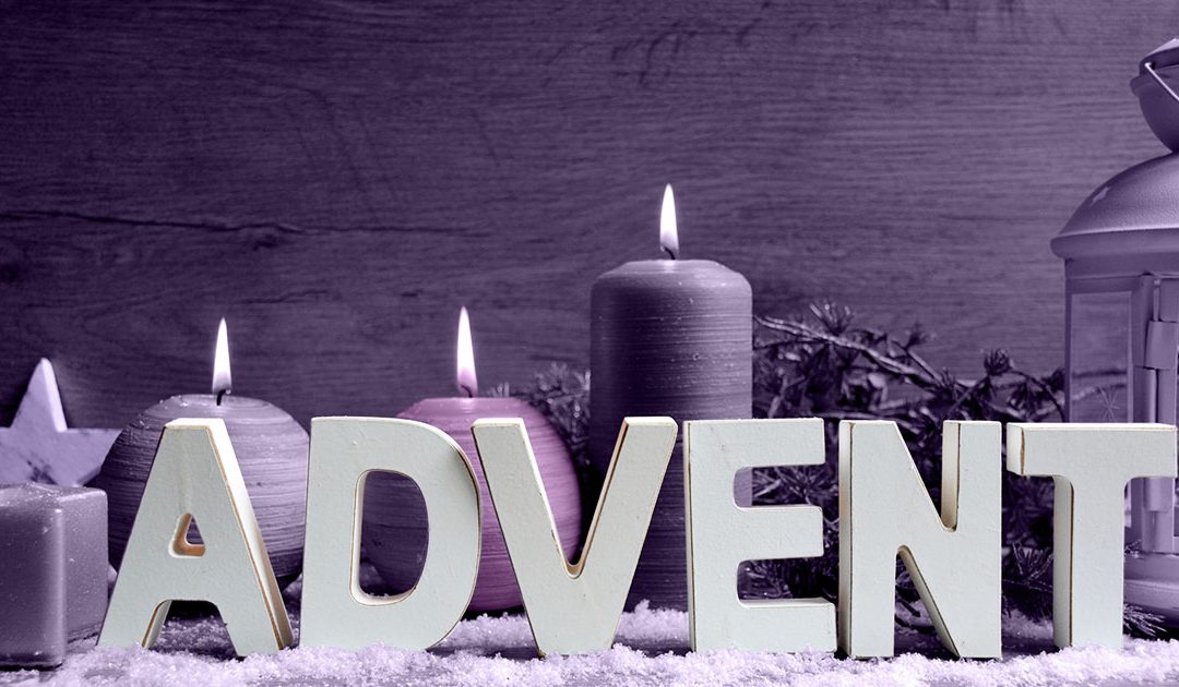 The word ADVENT in front of candles with a lantern on the side.